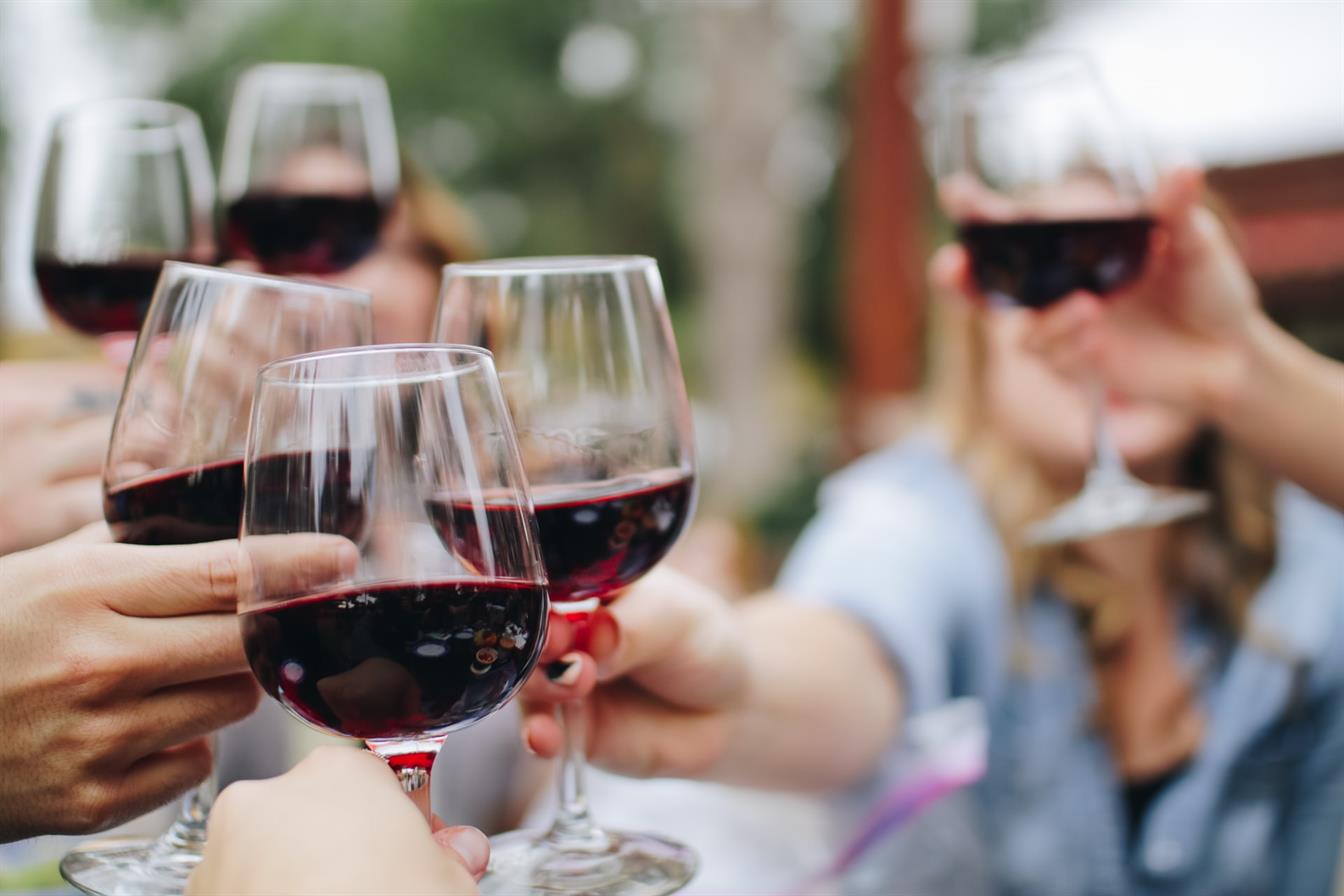 Auf einer Feier wird mit Rotwein angestoßen Anstoßen mit Rotwein
