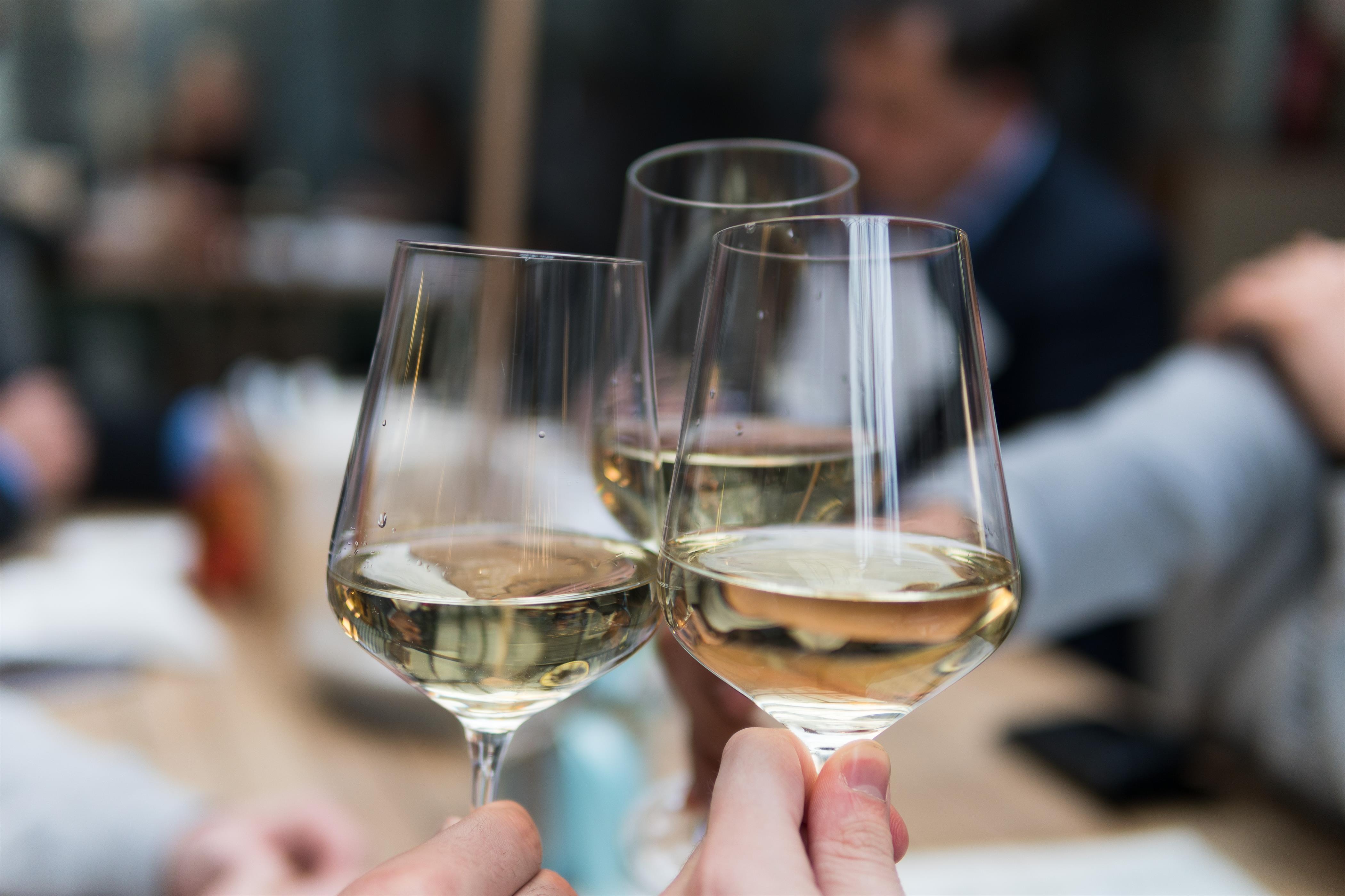 Drei Gläser Weißwein Es wird mit drei Gläsern Weißwein angestoßen